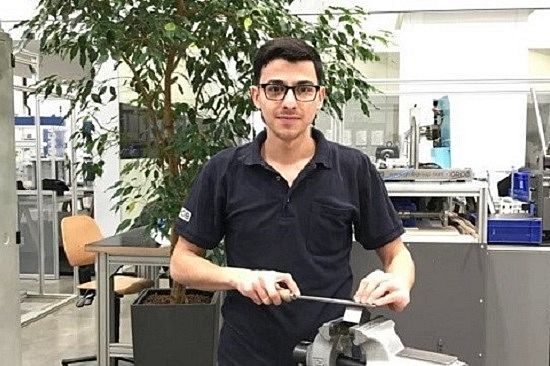 Industriemechaniker Youssef an einer Maschine in seinem Ausbildungsbetrieb.