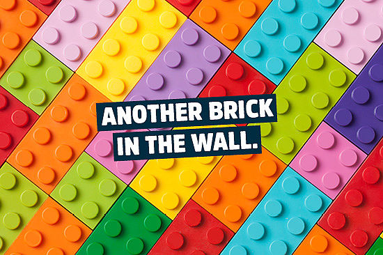 Foto: viele Legosteine, säuberlich aneinandergelegt. Text: „Another brick in the wall.“  