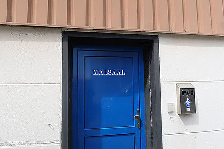 Kleine  blaue Tür mit der Aufschrift „Malsaal“.