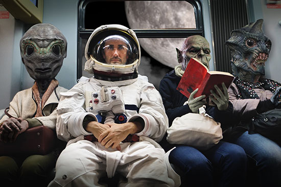 Szene aus der Zukunft: Ein Astronaut sitzt zwischen Außerirdischen auf einer Bank.